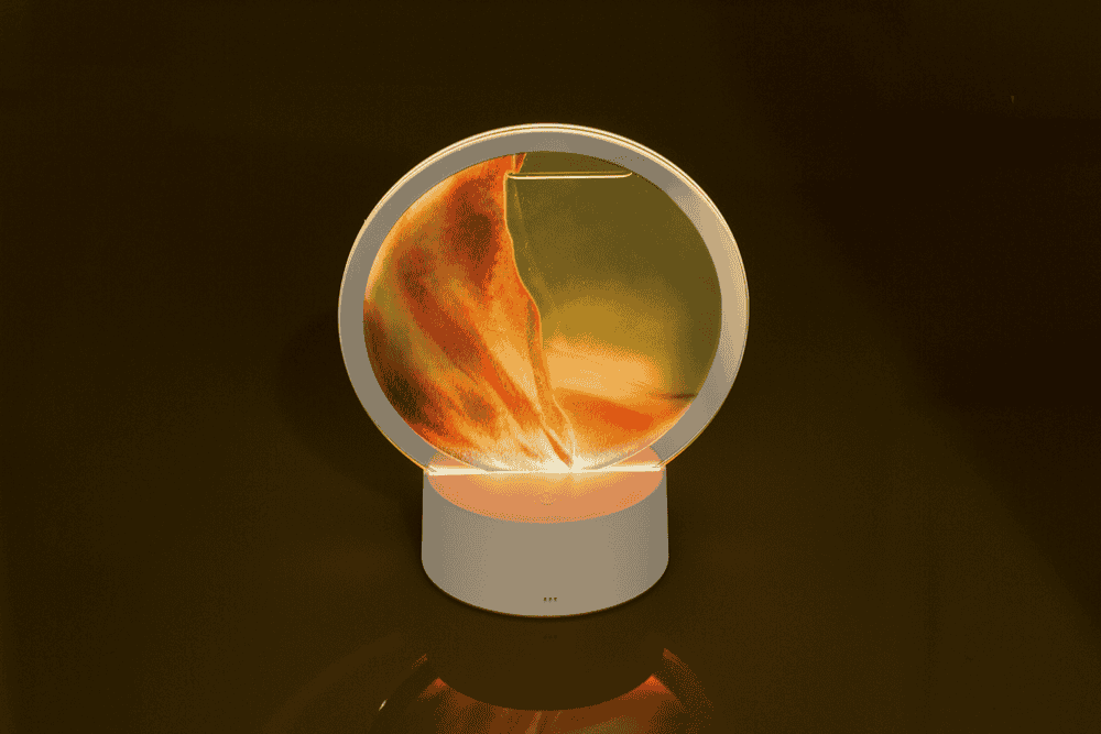 Rotating sand picture, with colour-changing LED