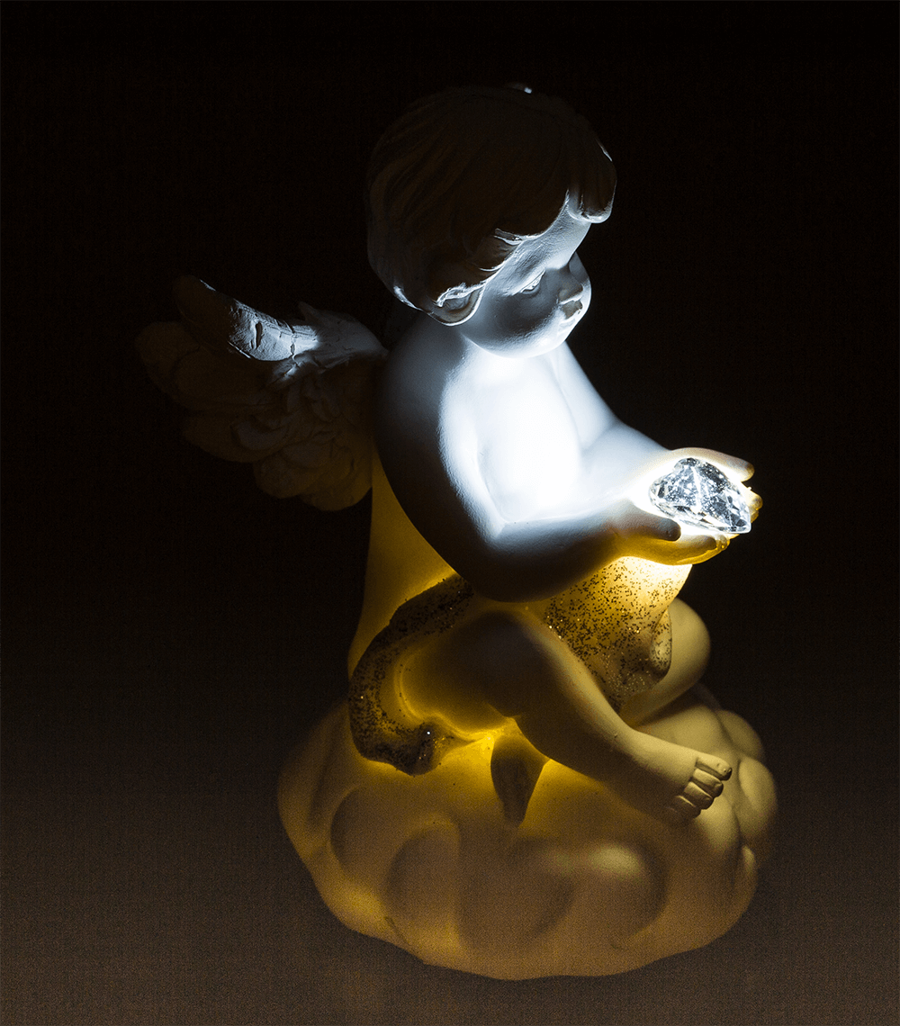 Sitting polyresin angel with white LED heart,